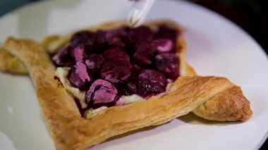 Önünde ve ortasında vişneli turta olan tatlı masası. Flaky, yapışkan ve buzlu. Yüksek kalite 4k görüntü