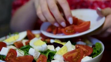 Salata hazırlamak için, taze, sulu, olgun domatesleri salata için dilimlemek üzere kesme tahtasına döker. Ağır çekim. Yüksek kalite 4k görüntü