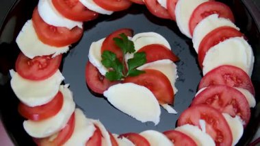 Mozzarella, vişneli domates ve fesleğenli Caprese salatası, daire şeklinde dönüyor. Dikey video. Yüksek kalite 4k görüntü