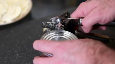Top View Man 'in elleri mısır kavanozunu açıyor. Koyu arkaplanda izole edilmiş metal kavanozdaki konserve mısır. Konserve açacağıyla bir konserve kutusu aç.