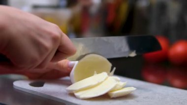 Taze mozzarella toplarını tahta kesme tahtasında küçük küplere ayırmak. Yüksek kalite 4k görüntü