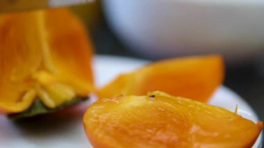 Olgun portakallı hurma parçalarını kesmek, taze hurma kullanarak yemek pişirmek, ki bu da parçalara bölünmüş. Yüksek kalite 4k görüntü