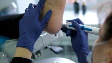 Ayak tedavisi prosedürü. Tırnak törpüsü matkabıyla donanım tıbbi pedikür. Pedikür tedavisi gören hasta. Özel bir cihazla kaplıcada ayak soyma tedavisi. Podoloji Kliniği.