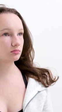 Çekici bir sarışının uçan saçının yavaş hareketi. Gri arka plan. Kadın rüzgar stüdyosu