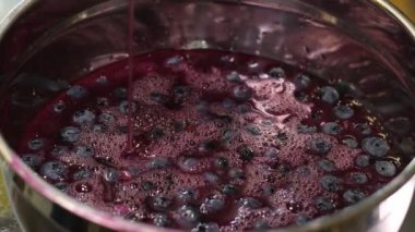 Şekerli böğürtlen reçeli, haşlanmış marmelat, bir kavanoz ahududu reçeli ve beyaz ahşap masa yapraklı taze böğürtlen pişiriyorum. Yüksek kalite 4k görüntü