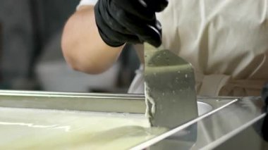 Kauçuk eldivenli, tanınmayan kadın fabrika işçilerinin elleri geleneksel peynir yapan mozzarella ve kakovala peynirinin seri üretimini esnetiyor. Yüksek kalite 4k