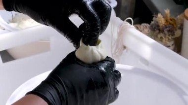 Kauçuk eldivenli, tanınmayan kadın fabrika işçilerinin elleri geleneksel peynir yapan mozzarella ve kakovala peynirinin seri üretimini esnetiyor. Yüksek kalite 4k