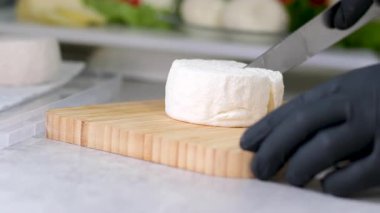 Bir el işi peynir fabrikasında çalışan bir işçi peynirin üzerine yumuşak peynir üretiyor. Camembert, Yemek pişirme süreci, adım adım