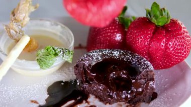 Yakın plan makro taze çilek, erimiş sıvı çikolatayla kaplı. Erimiş çikolata veya karamelli akarsu sulu kırmızı böğürtlenlerin üzerine dökülür. Şekerleme, lezzetli tatlı. Pişirme el yapımı 