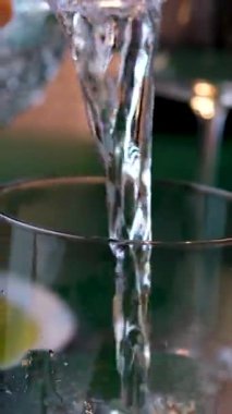 Saf İçme Suyu 'nu, Siyah Arkaplan' daki Islak Su Kadehi 'ne döküyorum. İzole edilmiş. Ağır çekim. Soğuk, ferahlatıcı su akıntısı bardağa dökülür. Su sıçraması.