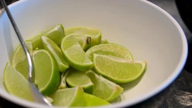 Limon dilimlerinin ve parçaların beyaz bir kasede üst görüntüsü, limonlu çin peyniri yapmak için malzemelerin üst görüntüsü. Misket limonu.