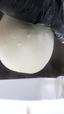 Kauçuk eldivenli, tanınmayan kadın fabrika işçilerinin elleri geleneksel peynir yapan mozzarella ve kakovala peynirinin seri üretimini esnetiyor. Yüksek kalite 4k