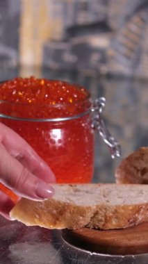 Mans elleri bir kaşık kırmızı havyarı bir parça ekmeğin üzerine koyar. İki kare düzenleniyor. Yakın plan. - Evet. Yüksek kalite 4k görüntü