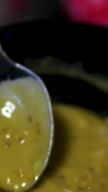 Altın kaşıkla hardal sosu, yakın çekim. Sosis, biftek ve salata için en popüler sos hardalı. Yüksek kalite 4k görüntü