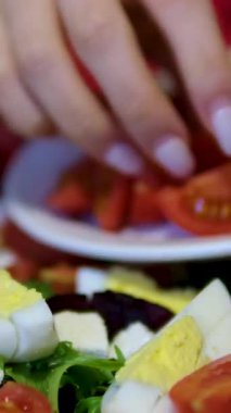 Salata hazırlamak için, taze, sulu, olgun domatesleri salata için dilimlemek üzere kesme tahtasına döker. Ağır çekim. Yüksek kalite 4k görüntü
