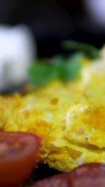 Omlet sosisli, domatesli makarna pesto ve tabakta feta öğle yemeği siyah tabaklar. Yüksek kalite 4k görüntü
