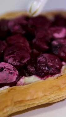 Önünde ve ortasında vişneli turta olan tatlı masası. Flaky, yapışkan ve buzlu. Yüksek kalite 4k görüntü