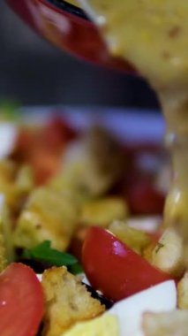 Kadın şef taze bebek salatasını karıştırıp cam üfleme içine salata sosu döker. Organik sebzeler yeşil salatayı cam kasede karıştırıyor. Kahvaltı taze salata ve temiz sebze. Yüksek kalite 4k görüntü