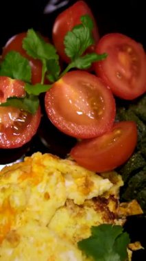Omlet sosisli, domatesli makarna pesto ve tabakta feta öğle yemeği siyah tabaklar. Yüksek kalite 4k görüntü