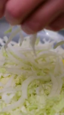 Çin lahanası kesmek, yaprakları ayırmak profesyonel bir restoran mutfağında malzeme ve ekipmanlarla dolu konteynerlerin arasında dururken. Yüksek kalite 4k görüntü