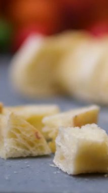 Bir el, mutfakta bir somun ekmeği tahta kesme tahtasıyla keser. Yüksek kalite 4k görüntü