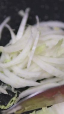 Çin lahanası kesmek, yaprakları ayırmak profesyonel bir restoran mutfağında malzeme ve ekipmanlarla dolu konteynerlerin arasında dururken. Yüksek kalite 4k görüntü