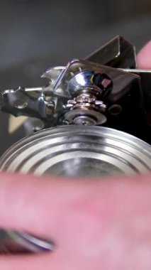 Top View Man 'in elleri mısır kavanozunu açıyor. Koyu arkaplanda izole edilmiş metal kavanozdaki konserve mısır. Konserve açacağıyla bir konserve kutusu aç.