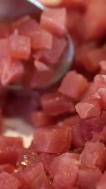 Ton balığı soslu arka plan, biftek. Taze çiğ ton balığı filetosu yakın plan, deniz balığı döner arka plan, üst manzara, düz yatak. Taze dilimlenmiş mavi yüzgeçli ton balığı, çiğ et dokusu. Salata için balığı küp küp doğra.