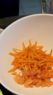 Sebzeli bir kase salata yapmak yeşillik, mayonez sosu, salatalık havucu, avokado ve mısır unu eldivenle hazırlamak, salata aşçısını elleriyle süslemek. Yüksek kalite