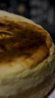 Çelik kek servis aletini dikkatlice kaldırırken ve tüm yuvarlak, yumuşak, fırınlanmış cheesecake tatlısının ilk üçgen dilimini bir tabakta çıkarırken. Yüksek kalite 4k görüntü