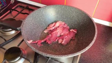 Bir şef mutfaktaki bir tavada biftek pişirir ve onu diğer tarafa çevirir, yakın plan yemek. Lezzetli biftek yapma süreci. Yüksek kalite 4k görüntü