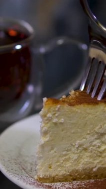 Bir insan küçük bir çatalla Matcha Burt Cheesecake 'in tadını çıkarıyor. Yüksek kalite 4k görüntü
