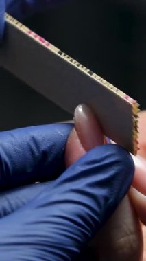 Güzellik salonundaki manikür ustasının manikür adım adım bütün hareketleri tırnak derisi lekesi temizleme jöle güçlendirici kadınların ellerini mavi eldivenlerle güçlendirme öz bakım sağlığına. Yüksek kalite 4k görüntü