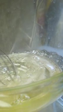 Karıştırıcı yumurta akını çırpıyor. Yumurta beyazını çırpma makinesiyle çırpmak. Krema yapıyorum. Yemek pişirme konsepti. 4K 'da yakın plan, UHD. Yüksek kalite 4k görüntü