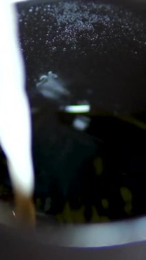 Latte sanatı yapılıyor. Cafe 'de yapılan kahve sanatının yakın çekim videosu. Süt, beyaz bardağa kahve ile dolduruluyor ve güzel bir latte sanatı yaratıyor. Bir fincan sade kahveye süt dök.