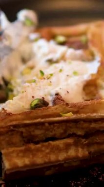 Erkek eller, çatal ve bıçakla çırpılmış kremayla kaplı Belçika wafflelarını kesiyor. Yüksek kalite 4K görüntü. Yüksek kalite 4k görüntü