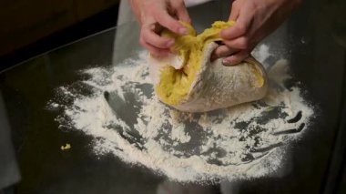 Masaya yakın plan kadın eli ile hamur yoğurmak. Ev yapımı un kekleri. Yapışkan hamuru ellerinle 