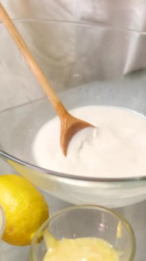 Tanınmayan kadın fırıncı hamura süt ekliyor, yavaşça karıştırıyor, hamuru ekmek pişirmek için hazırlıyor. Yüksek kalite 4k görüntü