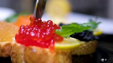 Olgun bir kadın kırmızı havyarlı tost yapıyor ve Paskalya için süslenmiş mutfakta yiyor. Yüksek kalite 4k görüntü