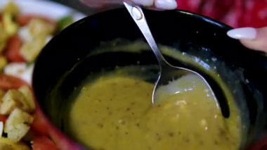 Altın kaşıkla hardal sosu, yakın çekim. Sosis, biftek ve salata için en popüler sos hardalı. Yüksek kalite 4k görüntü