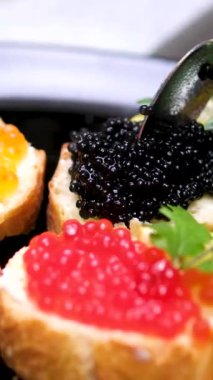 Sandviçin üstüne kaşık havyarı. Kırmızı havyar ve tereyağlı taze ekmek. Klasik lüks aperatif, gurme aperatifler ve zarif parmak yemekleri. - Evet. Yüksek kalite 4k görüntü