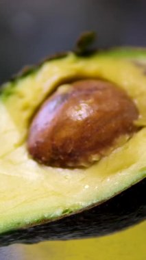 Yakın plan kesilmiş avokado, pişmiş guacamole, sağlıklı yiyecekler. Üst Manzara. Olgunlaşmış biraz bozulmuş avokado.