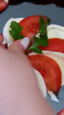 Basil, Hamile Kız ev mutfağında domatesli tost yapmaya odaklanıyor. Geniş açılı genç kadın, sabah tostu tarifi ve fesleğen yapraklarıyla taze peynirli tost hazırlıyor.