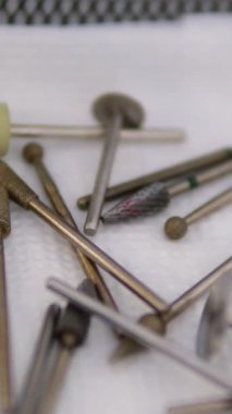 Aynalı yüzeyde gümüş tırnak makası. Masada manikür aletleri var.