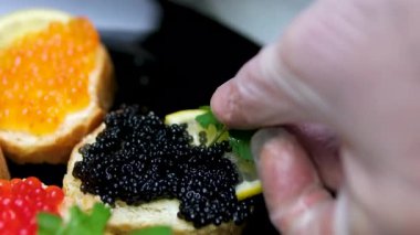 Ahşap arka planda siyah ve kırmızı havyarlı bölünmüş yemek. Yüksek kalite 4k görüntü