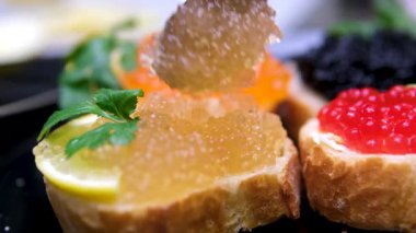 Tahta kesme tahtasının üzerinde kırmızı havyarla beyaz ekmek ve tereyağından sandviç pişirmek. Yüksek kalite 4k görüntü