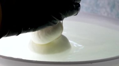 Ellerin ve tanınmayan kauçuk eldivenli kadın peynir fabrikası işçisinin göbeğine yakın çekim. Olgunlaşmak için mozarella 'nın elastik kütlesini oluşturuyorlar. Yüksek kalite 4k