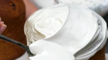 Yakın plan. El, Doğu Avrupa için lezzetli Ortodoks Paskalya ekmeği, geleneksel Rus ve Ukrayna paskalya pastası süsler ve serper. Beyaz kremalı Paskalya pastası 