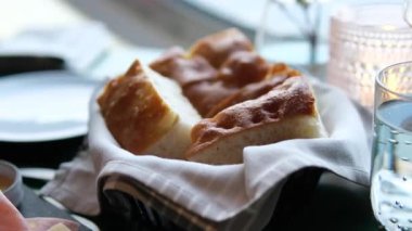 Masada taze ekmek var. Ekmek sepetinde ekmek. Hafif bir arka planda pişirme. Güneşli bir gün. Yüksek kalite 4k görüntü