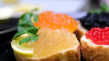 Gri masada lezzetli kırmızı havyarı ekmeğin üzerine koyan kadın, yakın plan. Yüksek kalite 4k görüntü